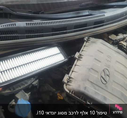 פילטר אוויר לרכב מוחזק מעל מנוע פתוח